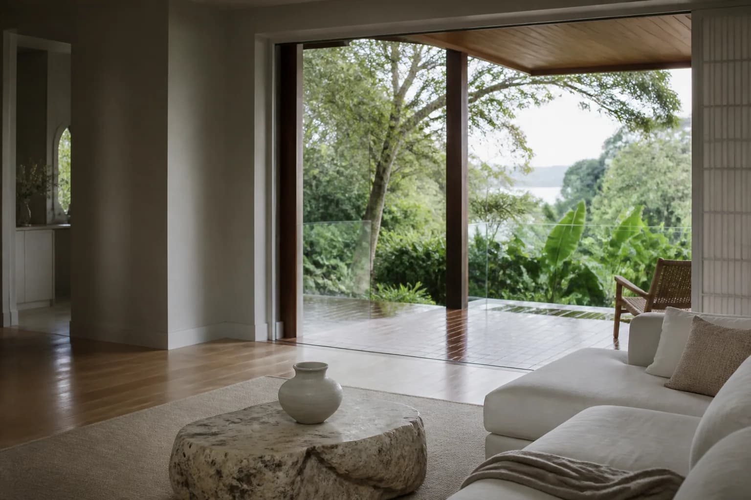A calm coastal home opening to rainforest greenery after rain